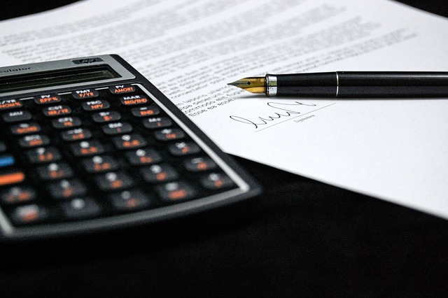 Calculator, pen, and paper on desk for Criteria for Proficiency assessment