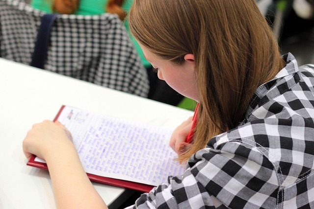 A girl at a table, writing in a notebook during TESOL Training